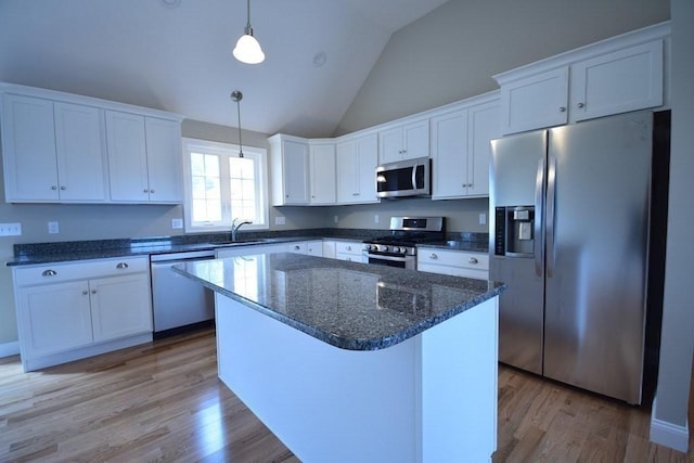 kitchen featuring white cabinetry, appliances with stainless steel finishes, decorative light fixtures, and a center island