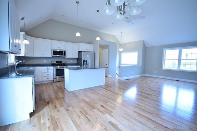 kitchen featuring sink, a center island, hanging light fixtures, appliances with stainless steel finishes, and white cabinets