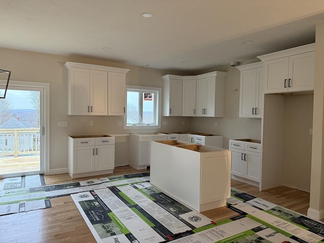 kitchen featuring white cabinetry, a center island, and light hardwood / wood-style flooring