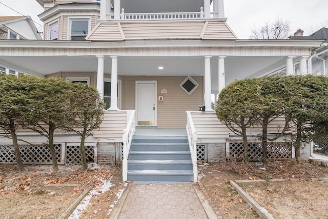 view of exterior entry featuring covered porch