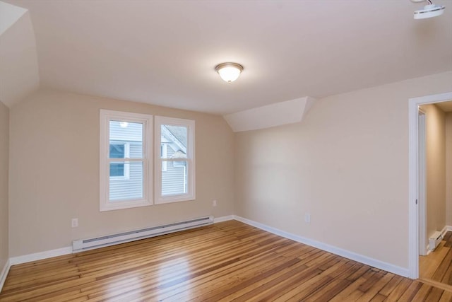 bonus room with light wood-type flooring, vaulted ceiling, and a baseboard heating unit