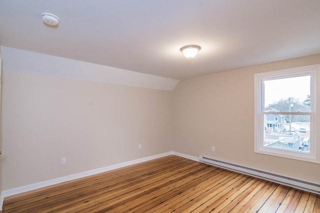 unfurnished room featuring hardwood / wood-style flooring, lofted ceiling, and baseboard heating