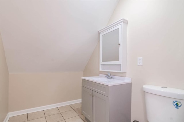 bathroom featuring tile patterned flooring, vanity, vaulted ceiling, and toilet