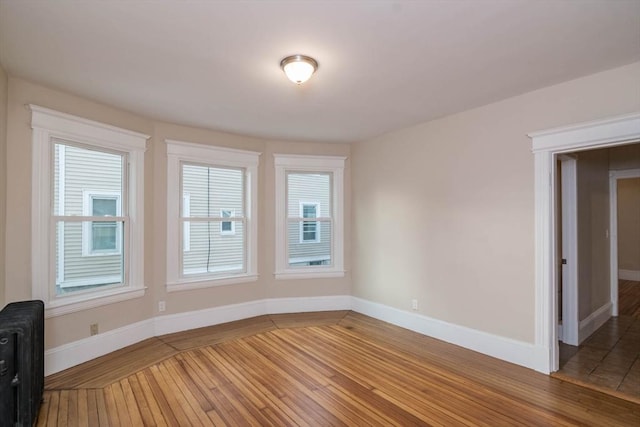 empty room with wood-type flooring and radiator