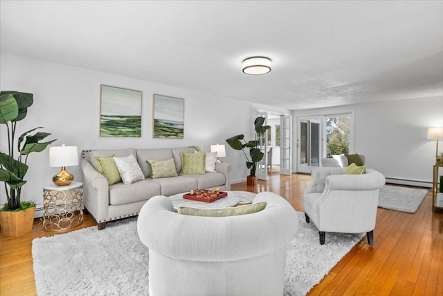 living area with a baseboard radiator and hardwood / wood-style flooring