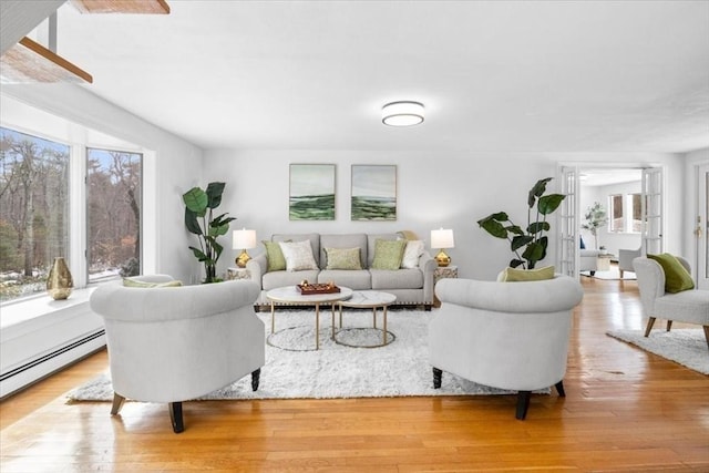 living room with light wood-type flooring and a baseboard heating unit