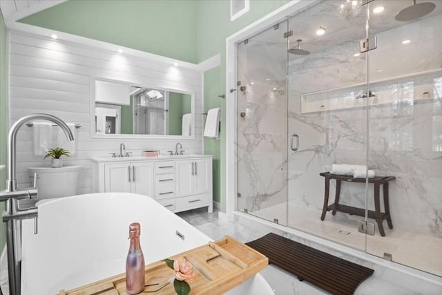 bathroom with marble finish floor, double vanity, a sink, and a marble finish shower