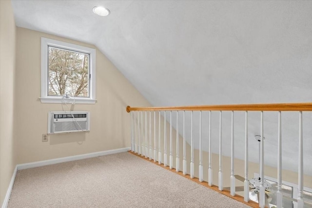 additional living space with carpet floors, baseboards, an AC wall unit, and lofted ceiling