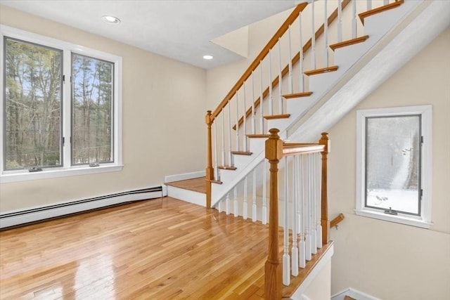 staircase featuring recessed lighting, baseboard heating, and wood finished floors