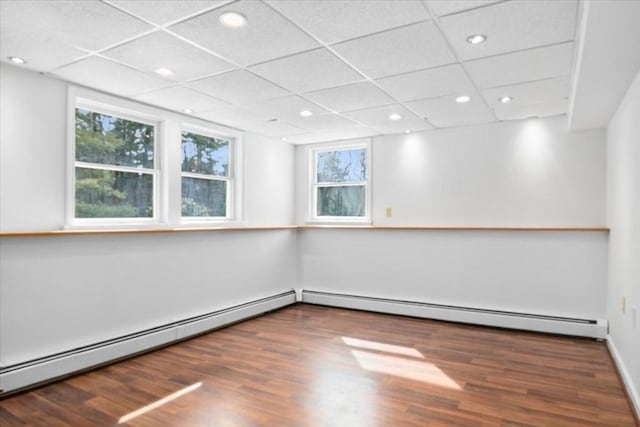 unfurnished room with a baseboard radiator, dark wood finished floors, and recessed lighting