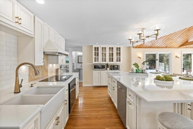 kitchen featuring glass insert cabinets, white cabinetry, appliances with stainless steel finishes, and light countertops