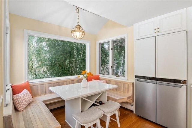 dining space featuring breakfast area, a wealth of natural light, light wood finished floors, and a baseboard radiator