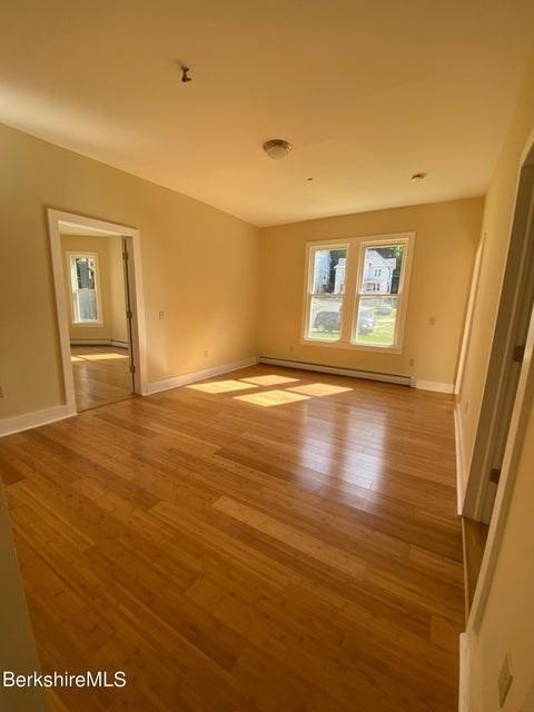 70-72 Chase Ave, North Adams, MA 01247 - empty room featuring light wood-style flooring, baseboard heating, and baseboards