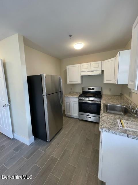 70-72 Chase Ave, North Adams, MA 01247 - kitchen featuring stainless steel appliances, wood finish floors, a sink, and white cabinetry