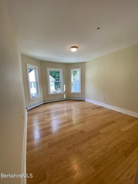 70-72 Chase Ave, North Adams, MA 01247 - empty room featuring light wood-style floors, baseboards, and a baseboard heating unit