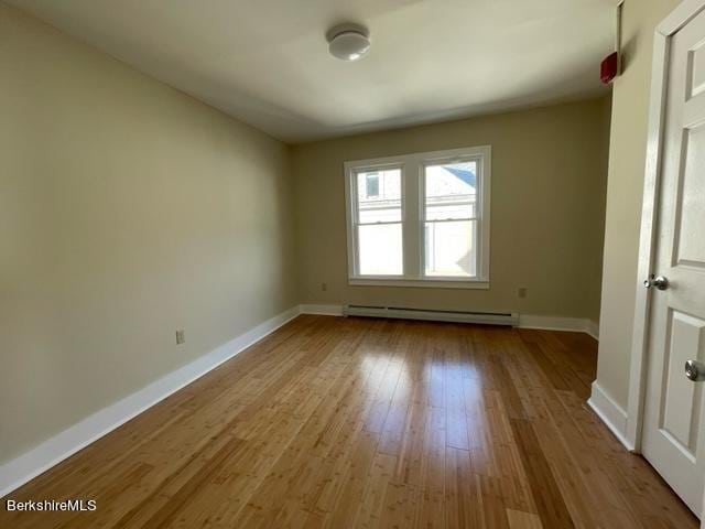 70-72 Chase Ave, North Adams, MA 01247 - empty room featuring a baseboard heating unit, baseboards, and wood finished floors