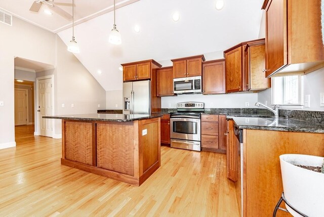 unfurnished living room featuring vaulted ceiling, a fireplace, ceiling fan, light hardwood / wood-style flooring, and ornamental molding