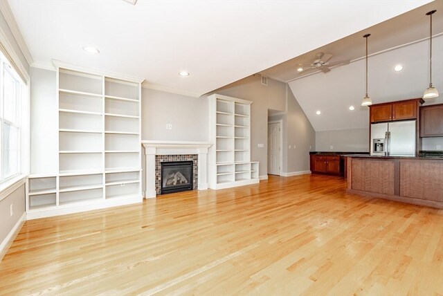 unfurnished living room with a brick fireplace, light hardwood / wood-style floors, and crown molding