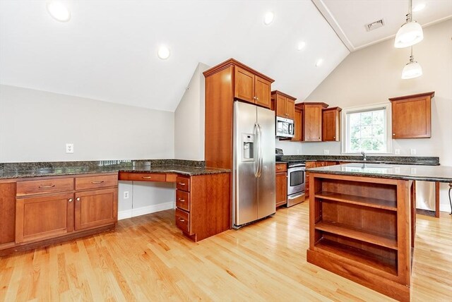 kitchen with stainless steel appliances, dark stone countertops, light hardwood / wood-style floors, and sink