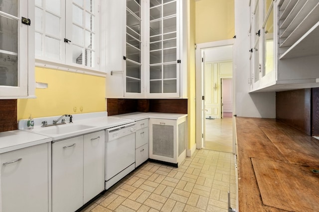 kitchen with light tile floors, sink, white cabinetry, and white dishwasher