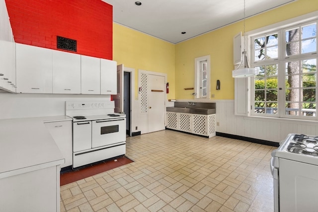 kitchen featuring hanging light fixtures, white cabinetry, white range with electric stovetop, and white range with gas cooktop