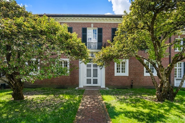 view of front of home featuring a front yard and a balcony