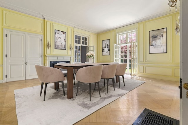 dining space with crown molding and light parquet floors