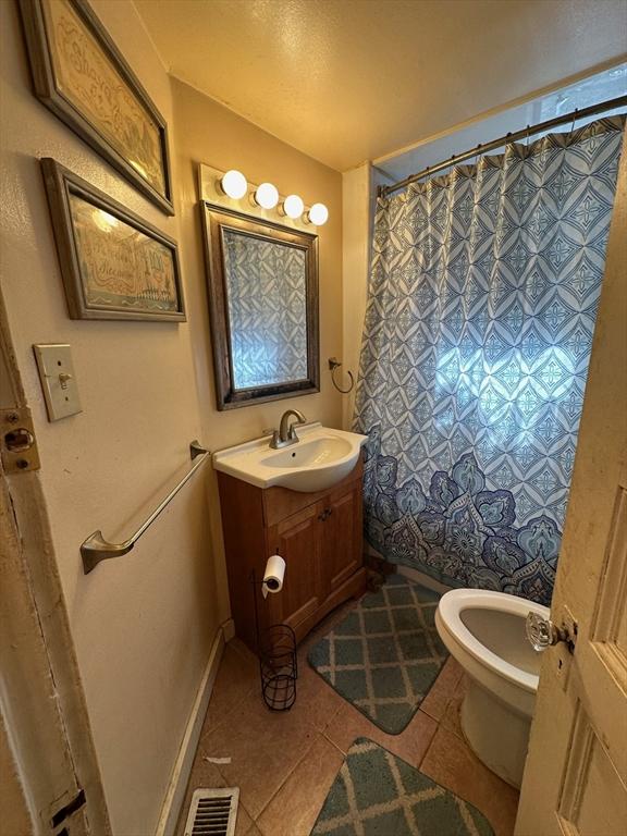 full bathroom featuring toilet, visible vents, curtained shower, tile patterned flooring, and vanity