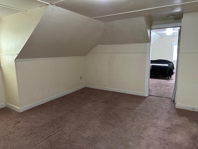 additional living space with carpet, vaulted ceiling, and baseboards