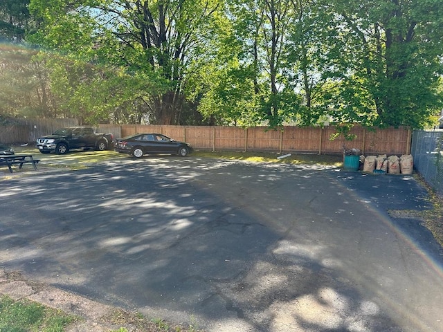view of parking / parking lot featuring fence