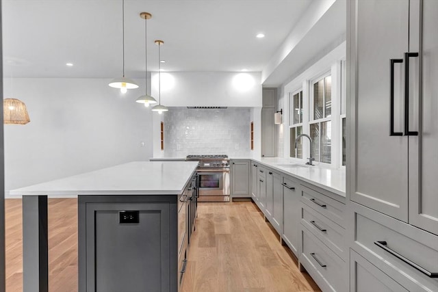 8A Milk St Unit 1, Newburyport, MA 01950 - kitchen featuring high end range, gray cabinetry, light wood-style flooring, light countertops, and tasteful backsplash