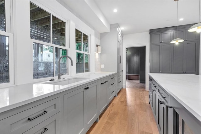 8A Milk St Unit 1, Newburyport, MA 01950 - kitchen with gray cabinets, light wood-style flooring, hanging light fixtures, recessed lighting, and light stone counters