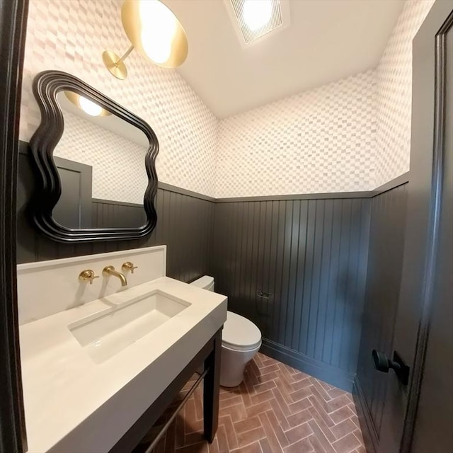 8A Milk St Unit 1, Newburyport, MA 01950 - bathroom featuring a wainscoted wall, wallpapered walls, vanity, and brick patterned floors