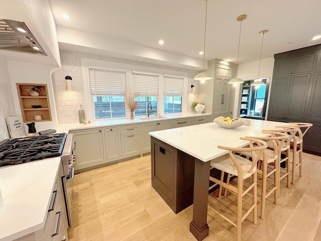 8A Milk St Unit 1, Newburyport, MA 01950 - kitchen with custom exhaust hood, recessed lighting, light countertops, a kitchen island, and a breakfast bar area
