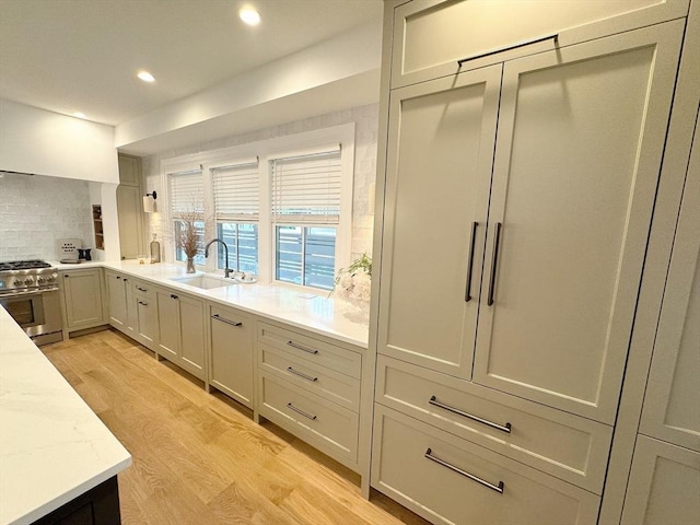 8A Milk St Unit 1, Newburyport, MA 01950 - kitchen featuring high end stove, light wood-style floors, decorative backsplash, recessed lighting, and light stone counters