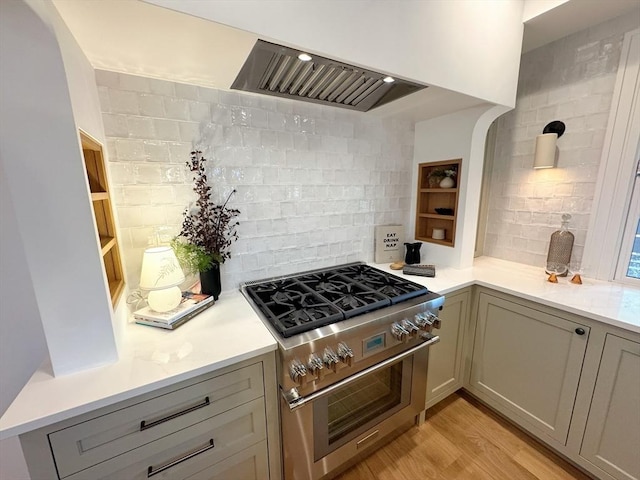 8A Milk St Unit 1, Newburyport, MA 01950 - kitchen featuring high end stove, decorative backsplash, light countertops, and light wood-style flooring