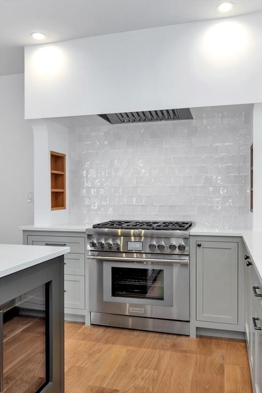 8A Milk St Unit 1, Newburyport, MA 01950 - kitchen featuring high end range, beverage cooler, light countertops, tasteful backsplash, and recessed lighting