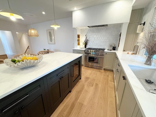 8A Milk St Unit 1, Newburyport, MA 01950 - kitchen featuring high end range, light wood finished floors, tasteful backsplash, light stone counters, and recessed lighting