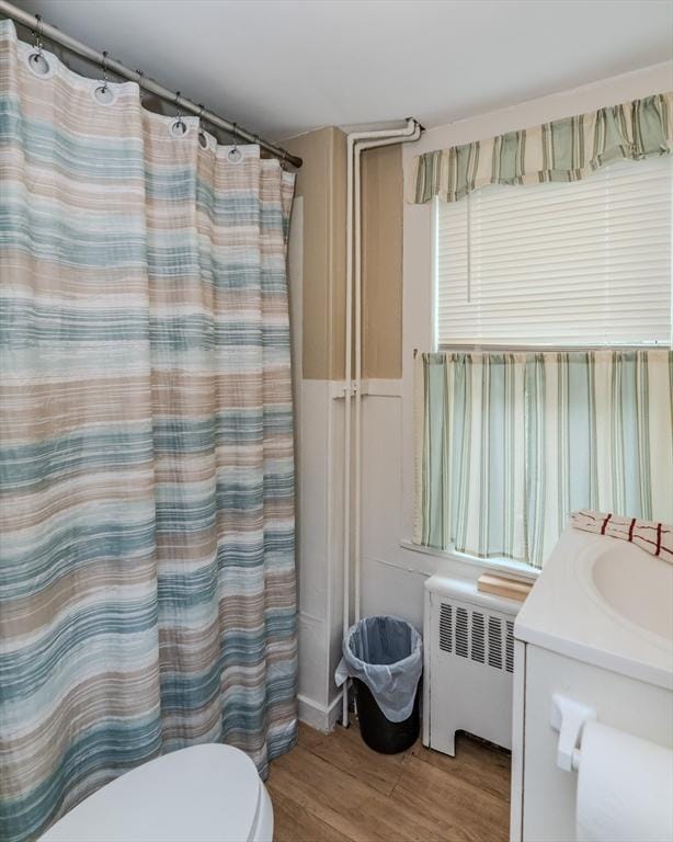 16 Fairfield Ave, Northampton, MA 01062 - bathroom featuring radiator, wood finished floors, toilet, vanity, and a shower with curtain