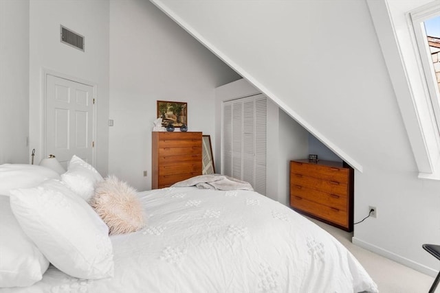 456 Belmont St Unit 21, Watertown, MA 02472 - bedroom with a closet, visible vents, light carpet, lofted ceiling, and baseboards