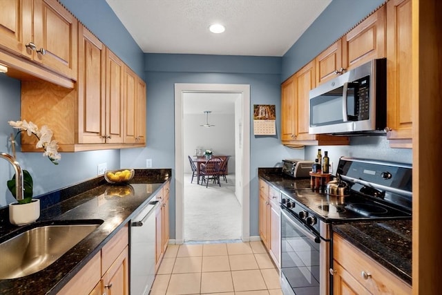 456 Belmont St Unit 21, Watertown, MA 02472 - kitchen featuring a toaster, light tile patterned flooring, dark stone counters, stainless steel appliances, and a sink