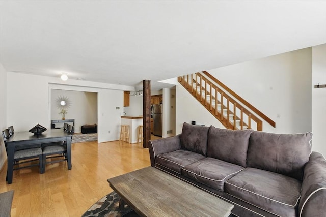 living area featuring light wood-style floors and stairway