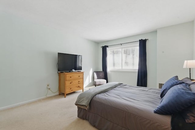 bedroom featuring light carpet and baseboards