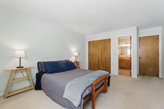 carpeted bedroom with ensuite bath, baseboards, and a closet