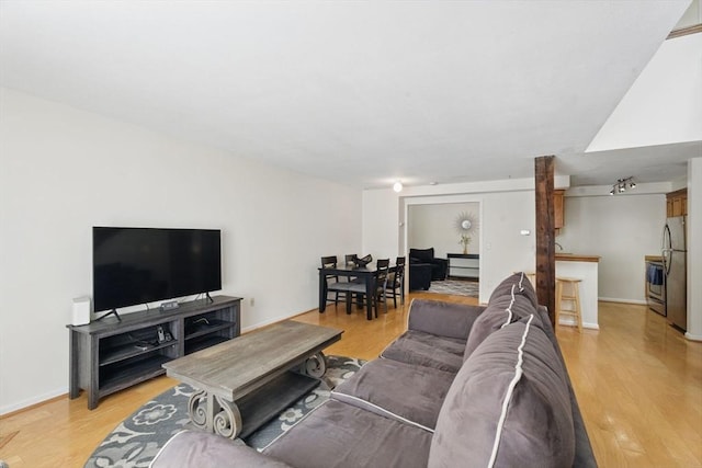 living area featuring light wood-style flooring and baseboards