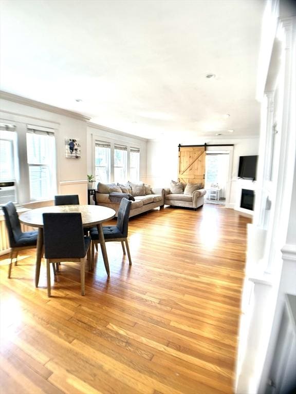 22-24 Ellison Ave Unit 1, Boston, MA 02126 - dining area with plenty of natural light, light wood-style floors, ornamental molding, a barn door, and cooling unit