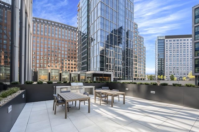 view of patio featuring an outdoor kitchen, a city view, and a grill
