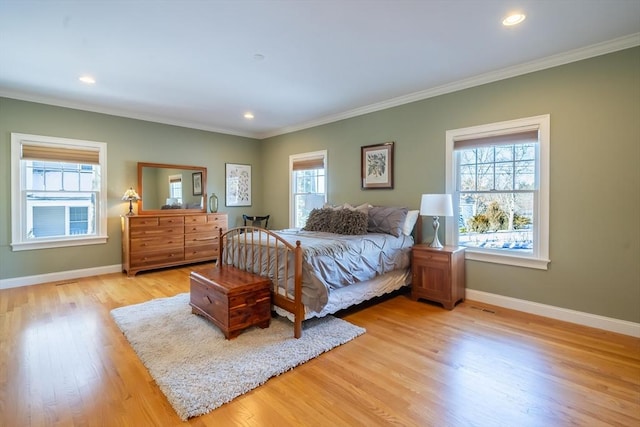 bedroom with ornamental molding, multiple windows, and light wood-type flooring