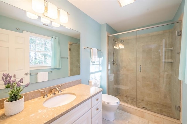 bathroom with an enclosed shower, vanity, tile patterned flooring, and toilet