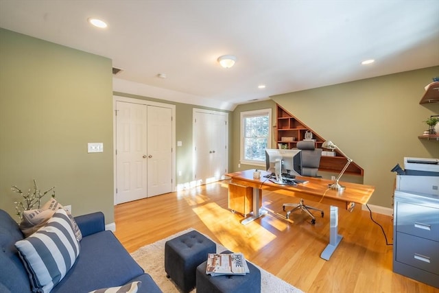 home office with lofted ceiling and light wood-type flooring